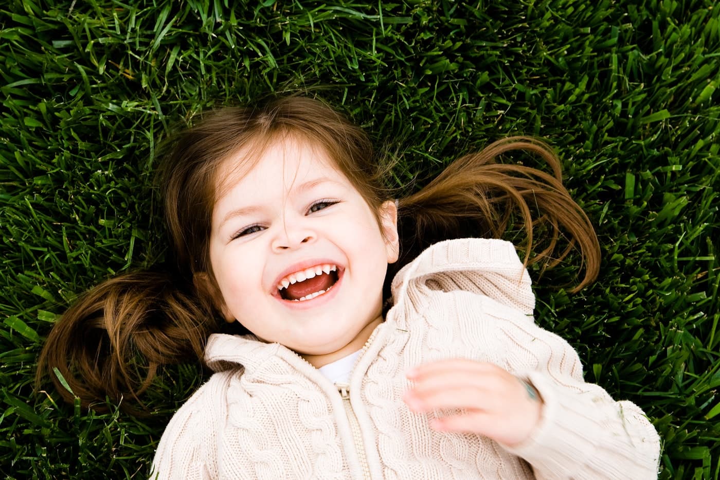 A little girl laughing in the grass